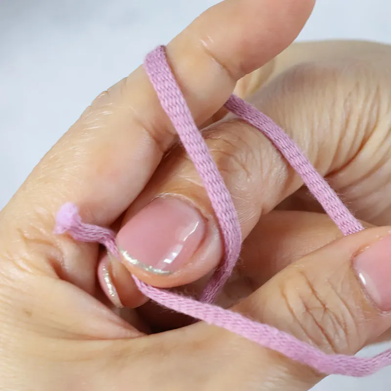 Insert your right hand's fingers through the gap between your left hand and the loop, and pinch to grab the yarn tail.