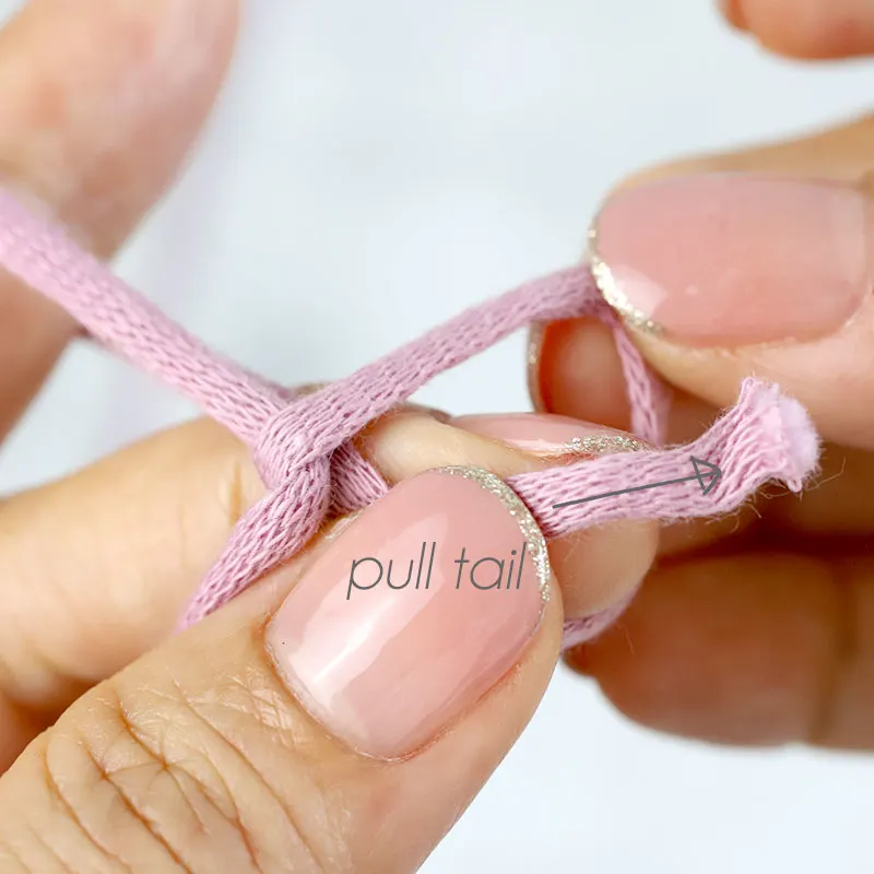 Feed the yarn tail through the loop.