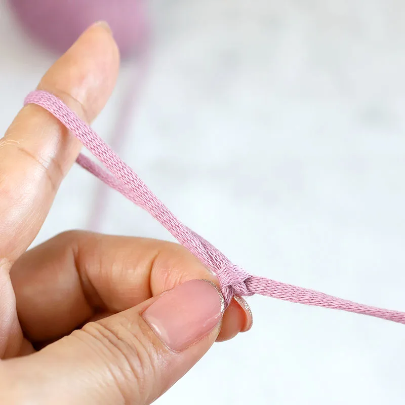 Pull the yarn end with your right hand to tighten the knot.