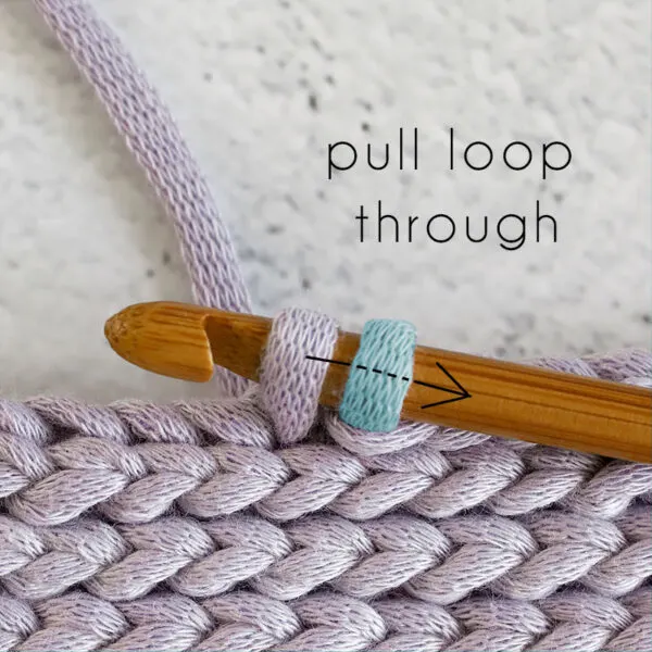 draw the first loop through the second loop to complete the crochet stitch